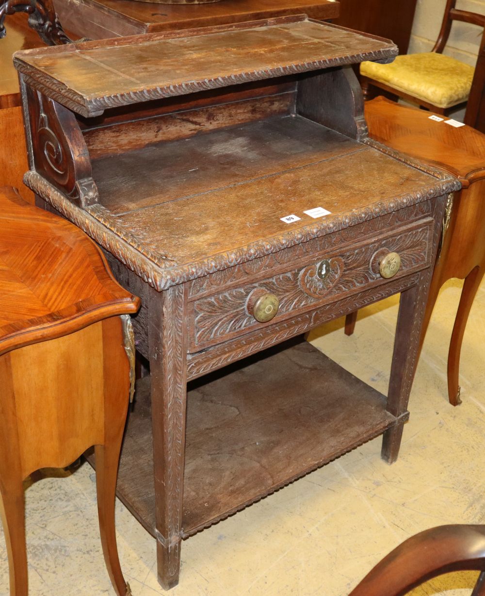 A late 19th century carved oak two tier table, fitted one drawer, W.72cm